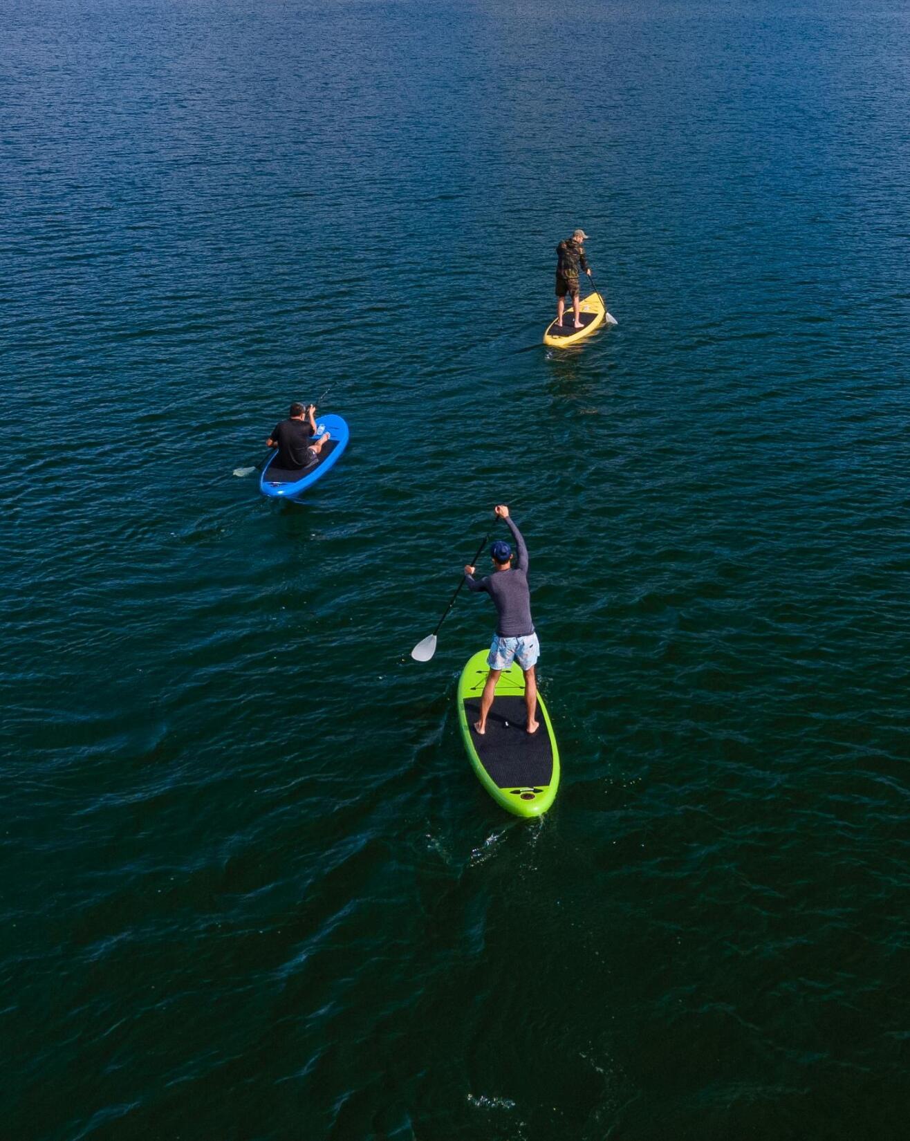 Aerial shot of a group of three people paddleboarding