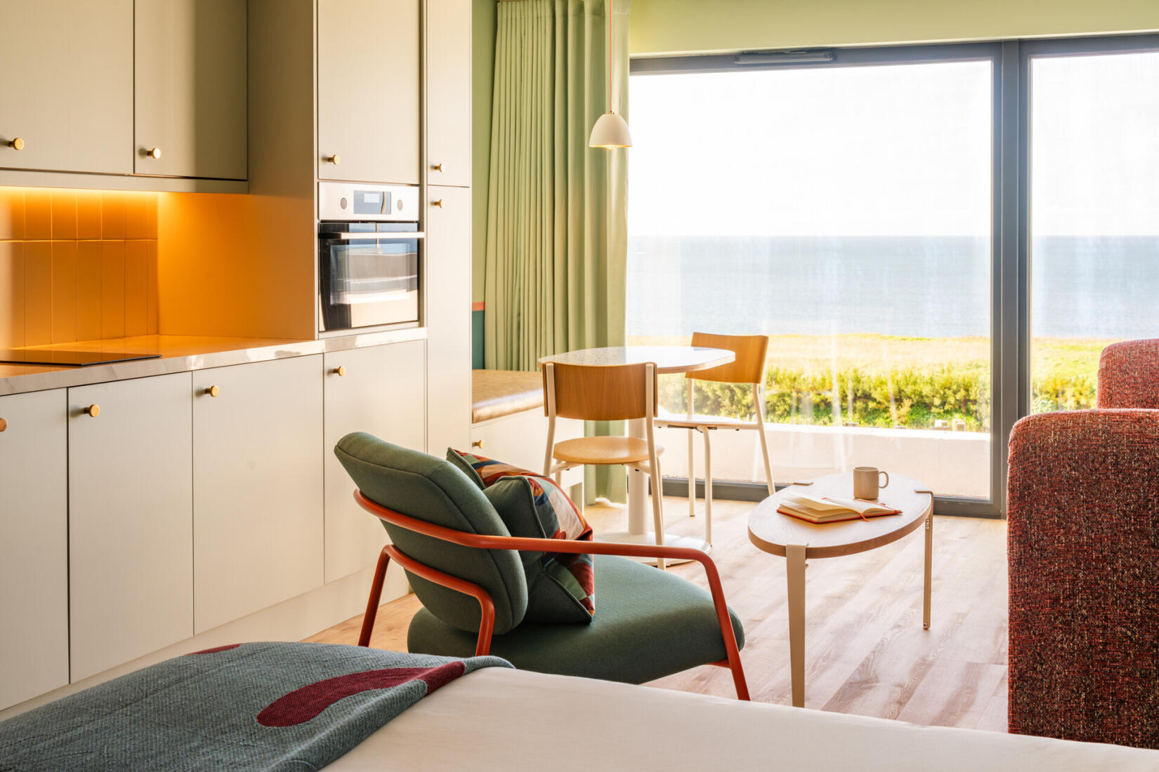 Bed, living area, and kitchen of a large studio with ocean views at SeaSpace