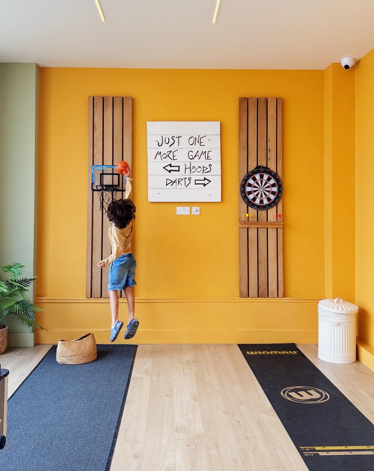 boy jumping to put a ball in the basketball hoop in the games room at SeaSpace