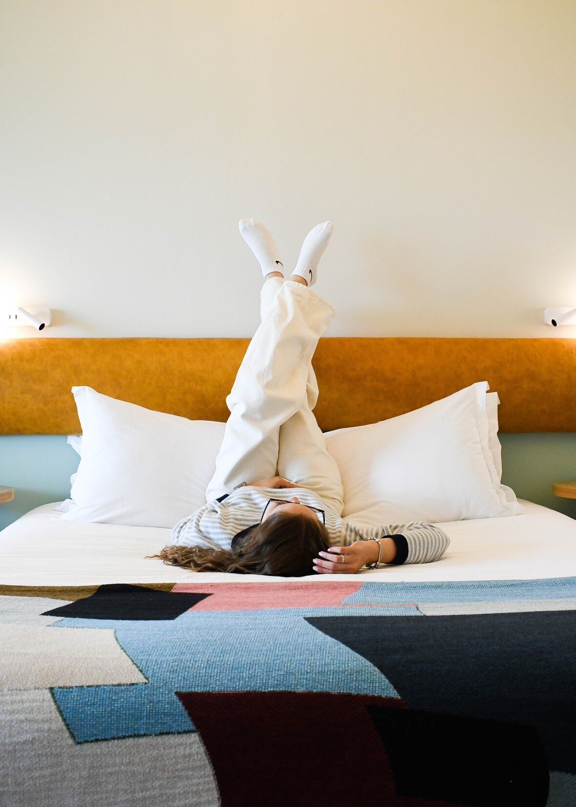 Girl on bed with feet up against the wall